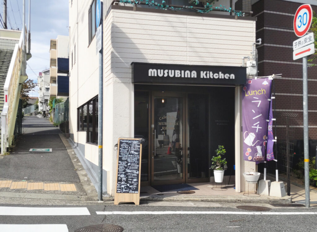 Cafe&Bar MUSUBINA KITCHENのお店を前から撮ったところ。白くて四角い建物です。