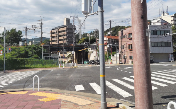 交差点の写真。神戸電鉄長田駅と鉄橋が画面奥に見えます。