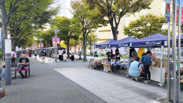 広場のような場所の横でやっていた、フリーマーケット＆マルシェ。石畳の場所で、青い屋根のテントがいくつも設営されています