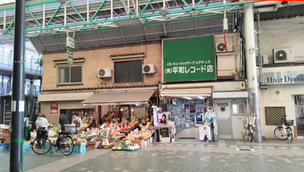 六間道商店街の中で営業していた八百屋さんとレコード屋さんを正面から撮影。どちらのお店もレトロな店構えです。